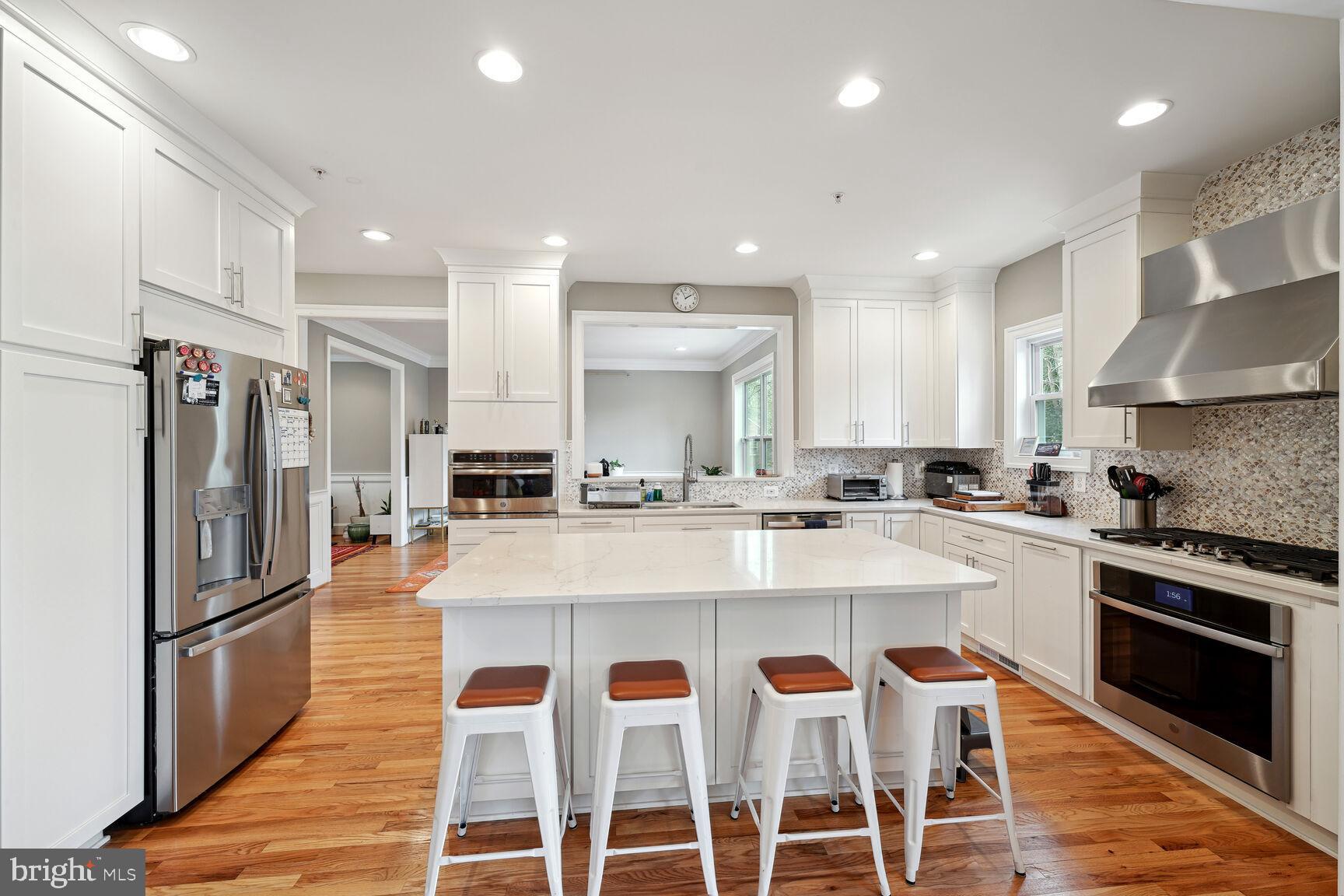 1907 Kermit Road Silver Spring, MD 20910 - Photo 7 of 20 a large kitchen with granite countertop a stove a sink a refrigerator and a dining table with wooden floor