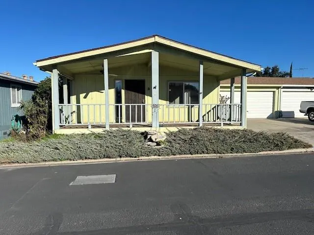 a view of a house with a yard and potted plants