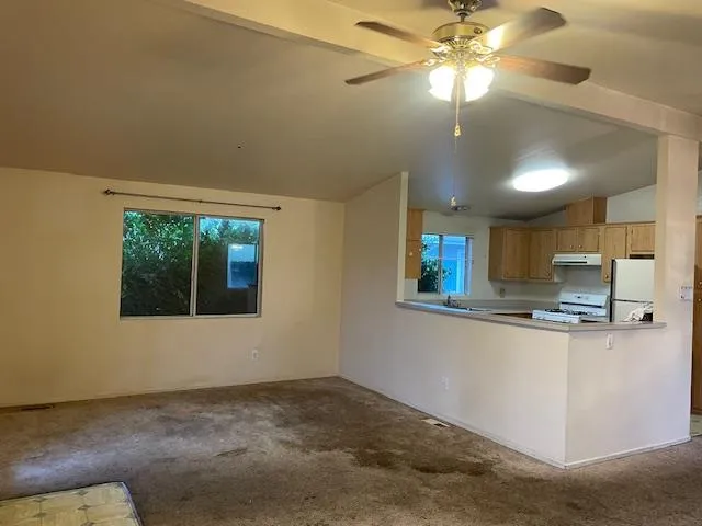 a view of a kitchen with a stove cabinets and a ceiling fan
