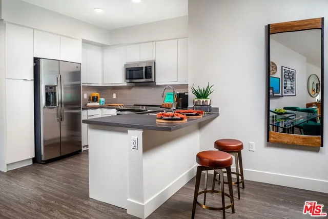 a kitchen with stainless steel appliances a microwave a sink and a refrigerator