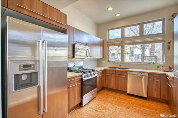 a kitchen with stainless steel appliances granite countertop a refrigerator and wooden cabinets