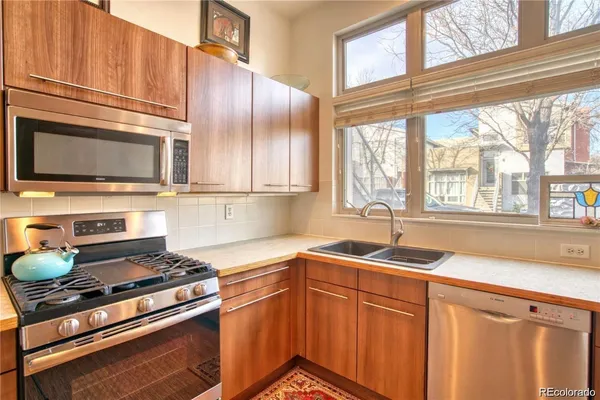 a kitchen with stainless steel appliances a stove sink and microwave