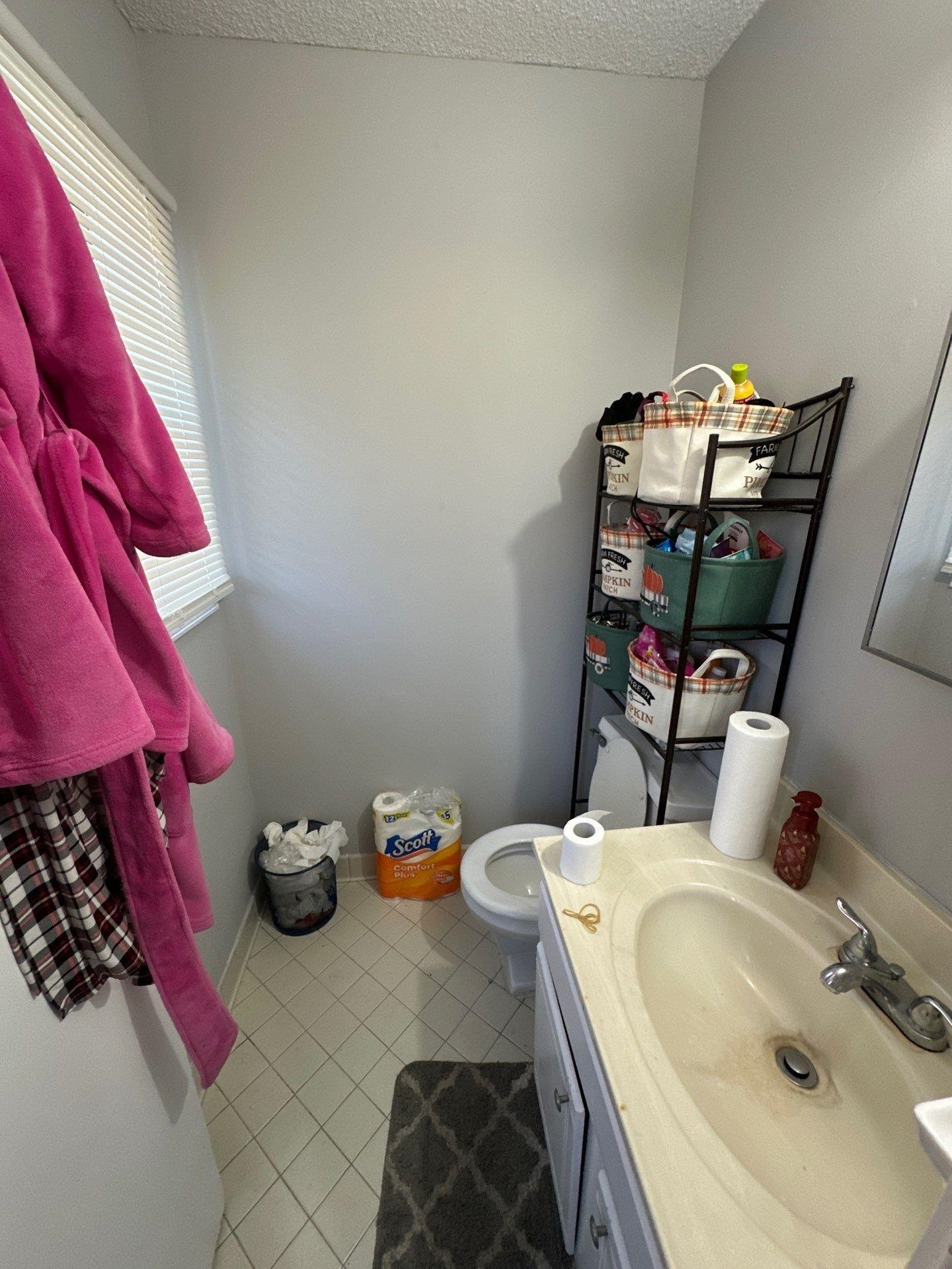 4712 Lofts Road Memphis, TN 38118 - Photo 6 of 7 Compact bathroom featuring a single vanity with an integrated sink, a toilet, and light-toned tile flooring
