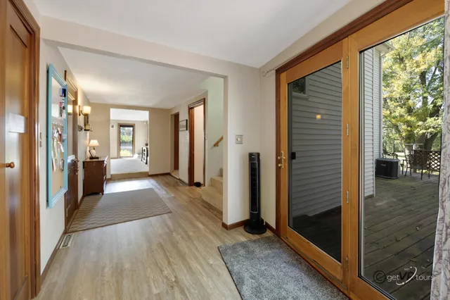 a view of a hallway with wooden floor and a living room