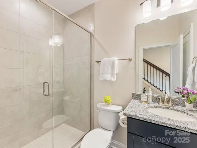 a bathroom with a granite countertop sink a toilet and shower