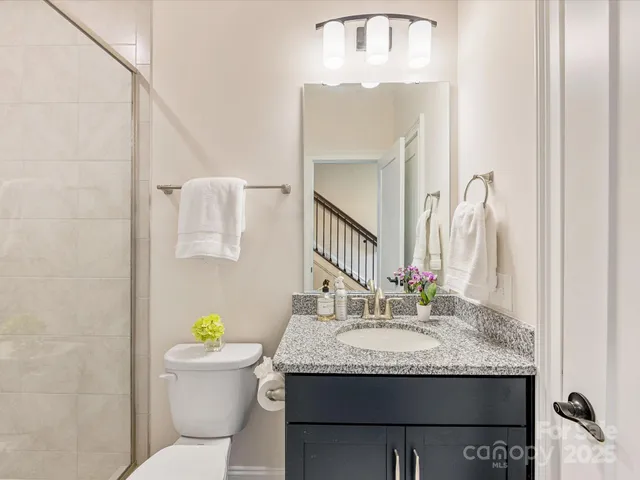 a bathroom with a granite countertop sink a toilet and a mirror
