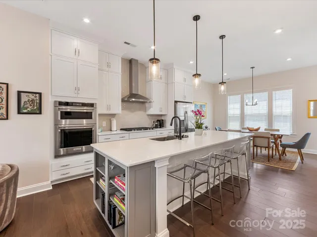 a large kitchen with kitchen island a stove a sink a dining table and chairs