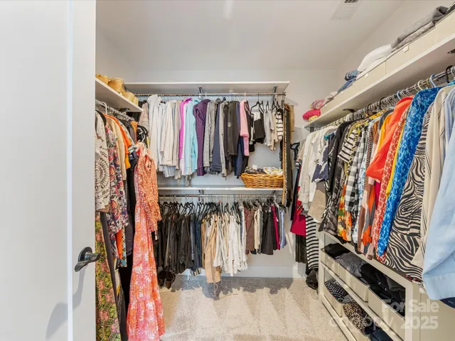 a view of walk in closet with clothes