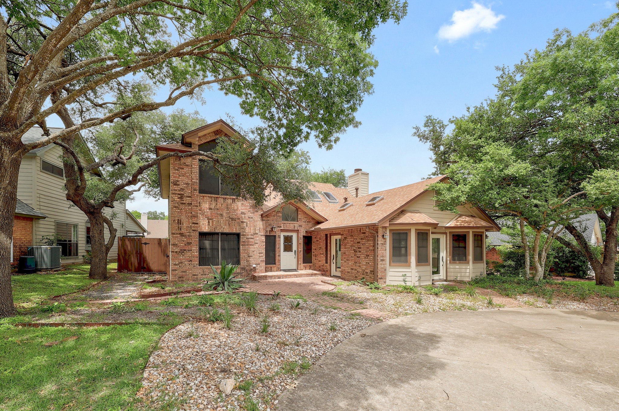 2202 Warfield Way Austin, TX 78728 - Photo 2 of 32 Mature trees frame this traditional brick home with an inviting front entry and mixed landscaping.