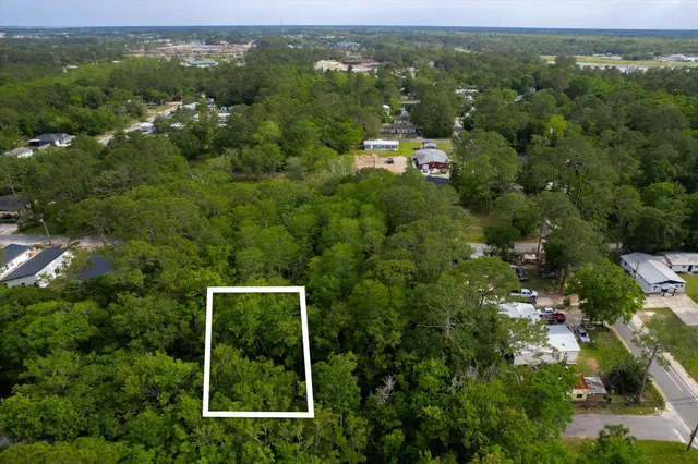 an aerial view of residential houses with outdoor space and trees