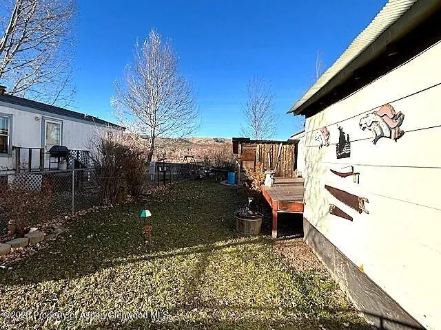 a backyard of a house with table and chairs