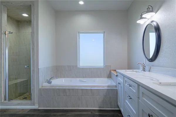 a bathroom with a tub sink and mirror
