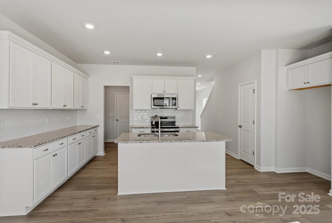 2716 Lehigh Road Charlotte, NC 28208 - Photo 3 of 7 a large kitchen with stainless steel appliances granite countertop a large counter top and a stove with wooden floor