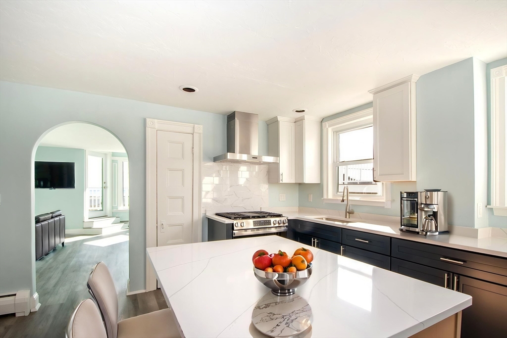 7 Whitehead Avenue, Unit 1 Hull, MA 02045 - Photo 11 of 32 a kitchen with stainless steel appliances granite countertop a sink and a refrigerator