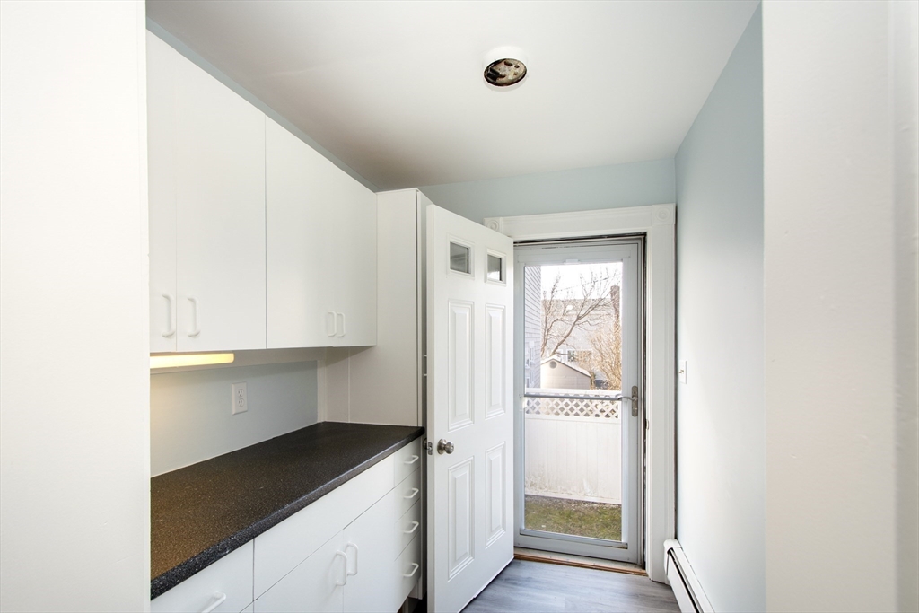 7 Whitehead Avenue, Unit 1 Hull, MA 02045 - Photo 12 of 32 a kitchen with granite countertop white cabinets and refrigerator