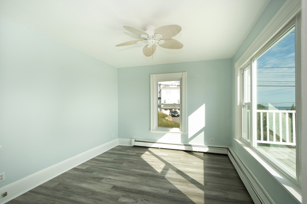 7 Whitehead Avenue, Unit 1 Hull, MA 02045 - Photo 24 of 32 an empty room with wooden floor fan and windows