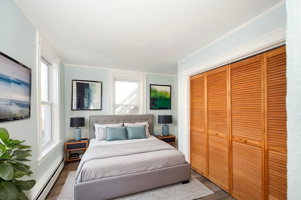 7 Whitehead Avenue, Unit 1 Hull, MA 02045 - Photo 26 of 32 a bedroom with a balcony a bed and a flat screen tv