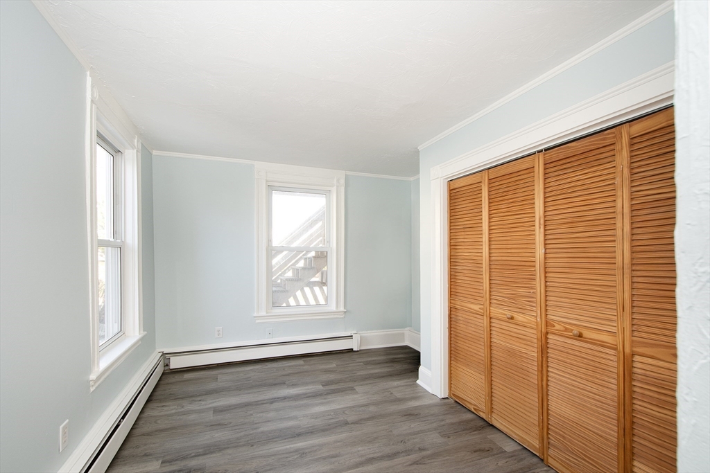 7 Whitehead Avenue, Unit 1 Hull, MA 02045 - Photo 27 of 32 an empty room with wooden floor and windows