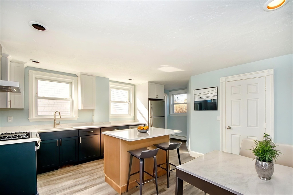 7 Whitehead Avenue, Unit 1 Hull, MA 02045 - Photo 7 of 32 a kitchen with a sink refrigerator and cabinets