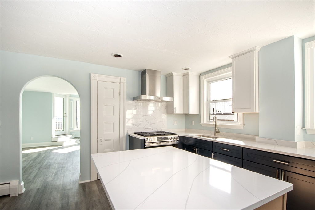 7 Whitehead Avenue, Unit 1 Hull, MA 02045 - Photo 10 of 32 a kitchen with granite countertop a refrigerator and a stove top oven