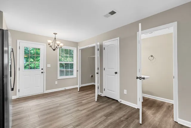 an empty room with wooden floor and windows