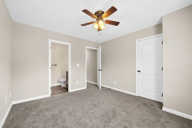 an empty room that has a ceiling fan and a window