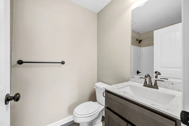 a bathroom with a granite countertop sink toilet and a mirror
