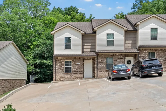 a car parked in front of a white house