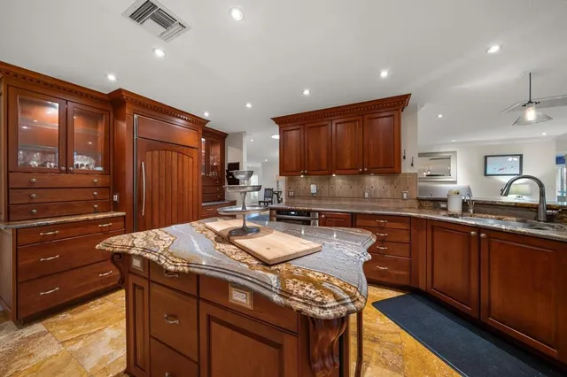 a kitchen with stainless steel appliances granite countertop a stove a sink and a microwave
