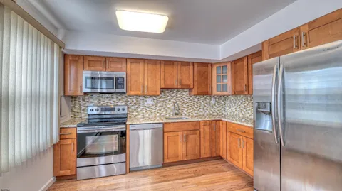 a kitchen with stainless steel appliances granite countertop a refrigerator and a stove top oven