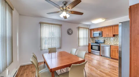 a large kitchen with a table chairs refrigerator and cabinets