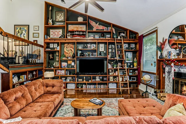 a living room with fireplace furniture and a book shelf