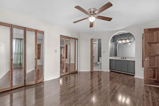 a view of a hallway with wooden floor and a living room