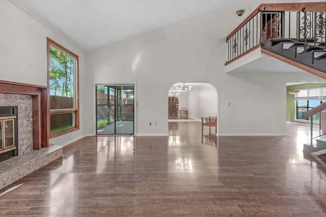 a view of empty room with fireplace and wooden floor