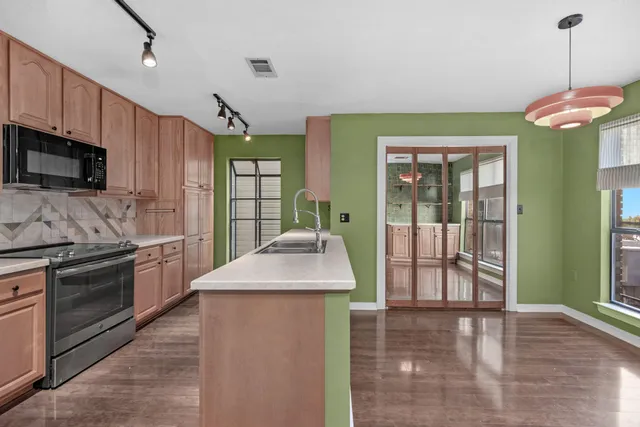 a kitchen with stainless steel appliances granite countertop a stove a sink and a refrigerator