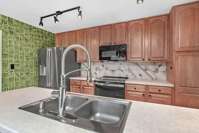 a kitchen with stainless steel appliances granite countertop a sink a stove and cabinets