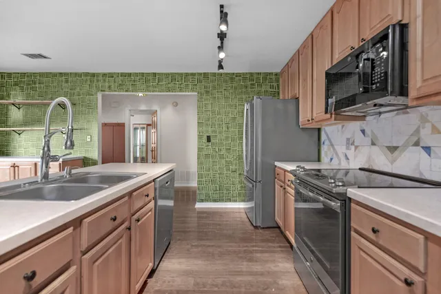 a kitchen with stainless steel appliances granite countertop a sink stove and refrigerator