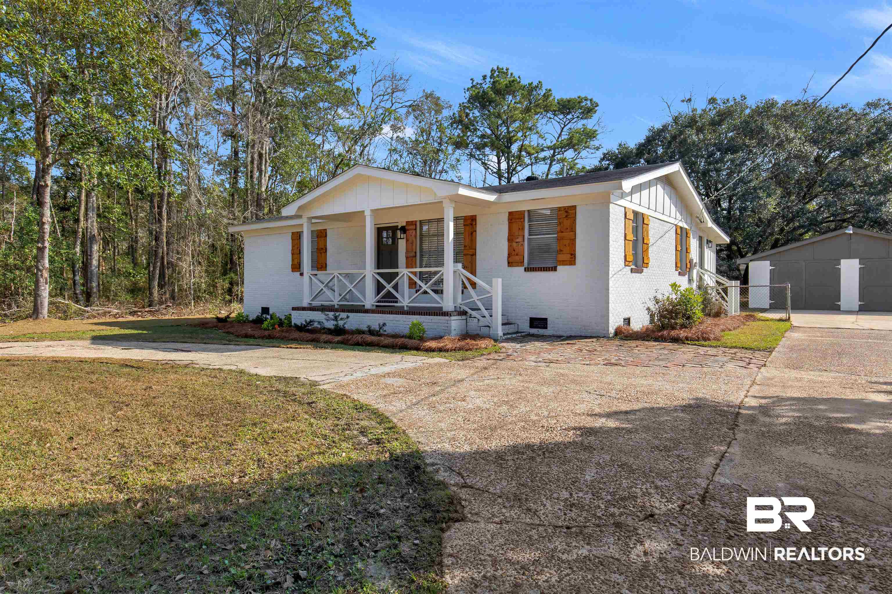 View of front of home featuring covered porch, a front lawn, and an outdoor structure