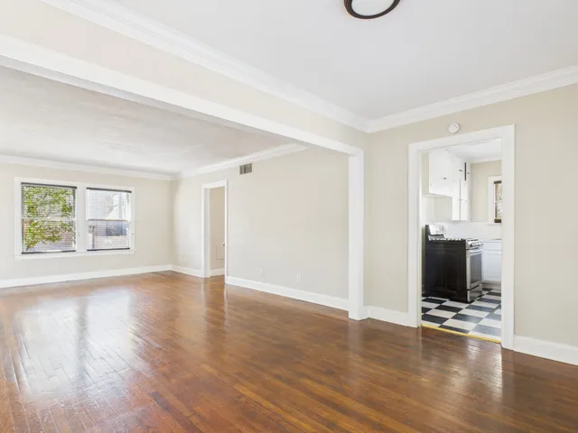 a view of a livingroom with wooden floor and a flat screen tv