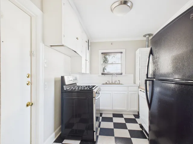 a kitchen with a refrigerator sink and white cabinets