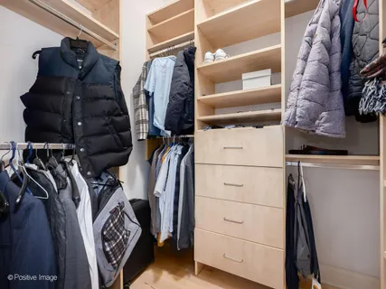 a view of walk in closet with clothes