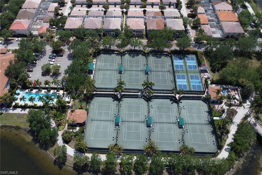 5365 Guadeloupe Way Naples, FL 34119 - Photo 34 of 47 an aerial view of a residential apartment building with a yard and parking spaces