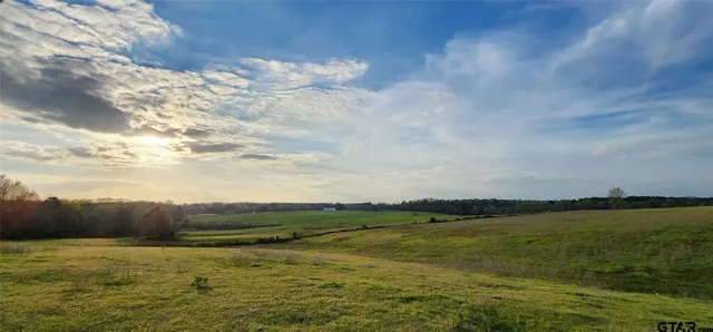a view of a lake with lawn chairs and a table