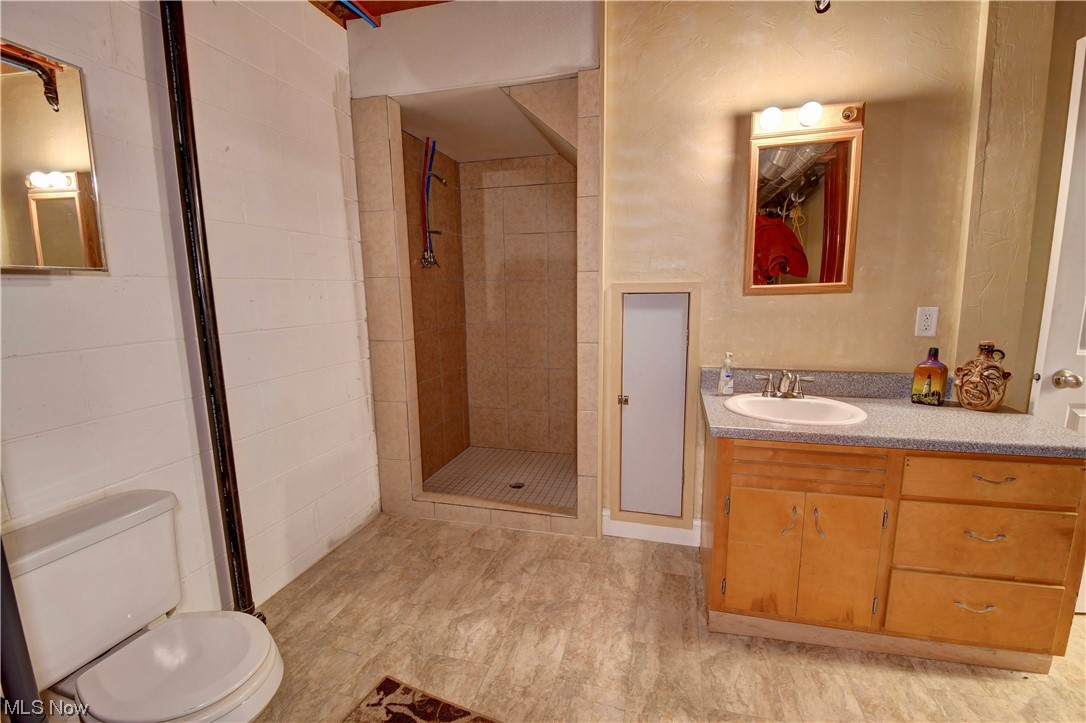 4301 Murray Road Dover, OH 44622 - Photo 34 of 49 Bathroom with tile flooring, vanity with extensive cabinet space, toilet, and tiled shower