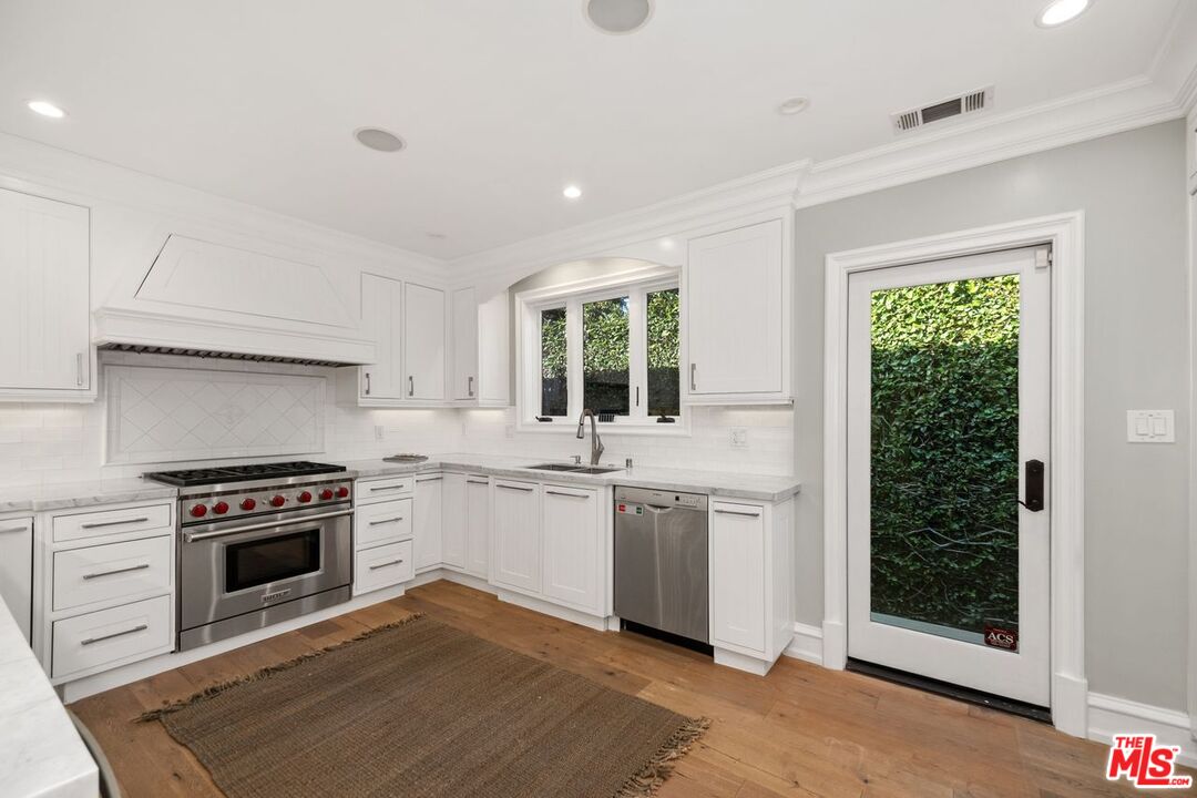 514 Walden Drive Beverly Hills, CA 90210 - Photo 22 of 59 a kitchen with stainless steel appliances granite countertop a stove a sink and a refrigerator