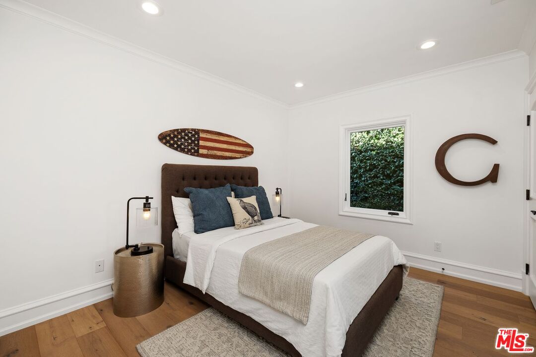 514 Walden Drive Beverly Hills, CA 90210 - Photo 31 of 59 a bedroom with a bed and a chandelier