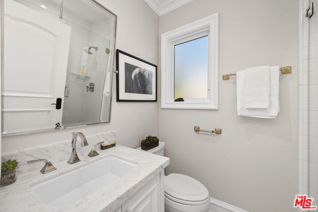 514 Walden Drive Beverly Hills, CA 90210 - Photo 32 of 59 a bathroom with a toilet sink and mirror