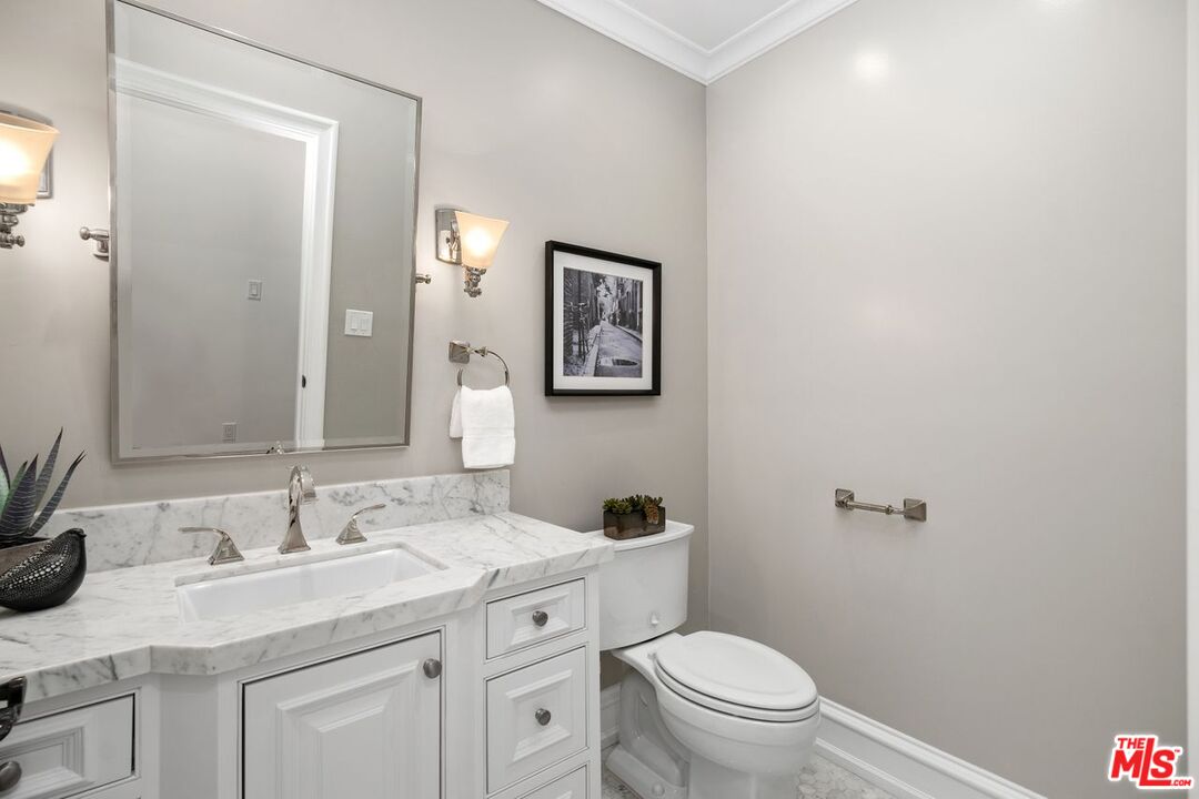 514 Walden Drive Beverly Hills, CA 90210 - Photo 33 of 59 a bathroom with a granite countertop sink a toilet and a mirror