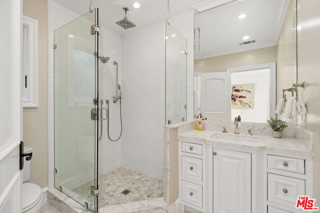 514 Walden Drive Beverly Hills, CA 90210 - Photo 36 of 59 a bathroom with a shower sink vanity granite and a mirror