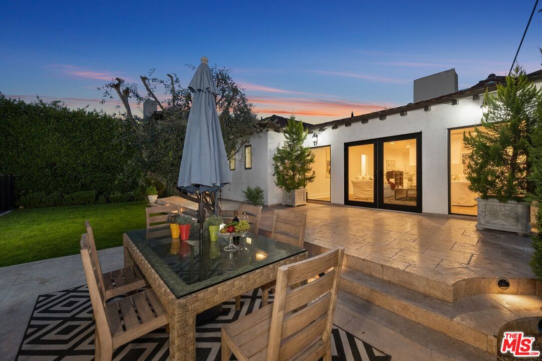 514 Walden Drive Beverly Hills, CA 90210 - Photo 40 of 59 a view of a patio with table and chairs with wooden floor and fence